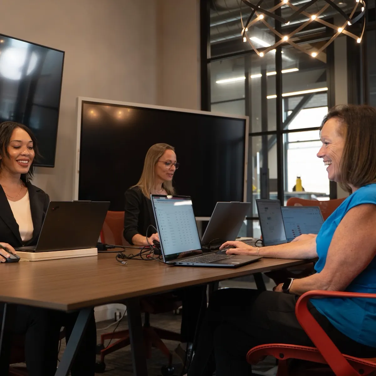 Sympl Benefits team members working together on laptops in their Ada, Michigan office